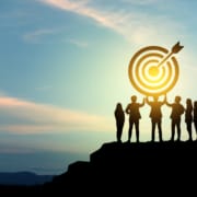 Goal setting towards planning for the future. Silhouettes of group businessmen holding target boards with flags planted on a mountain. Ett högpresterande team som nått målet tillsammans